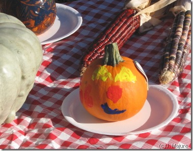 child-decorated pumpkin at market